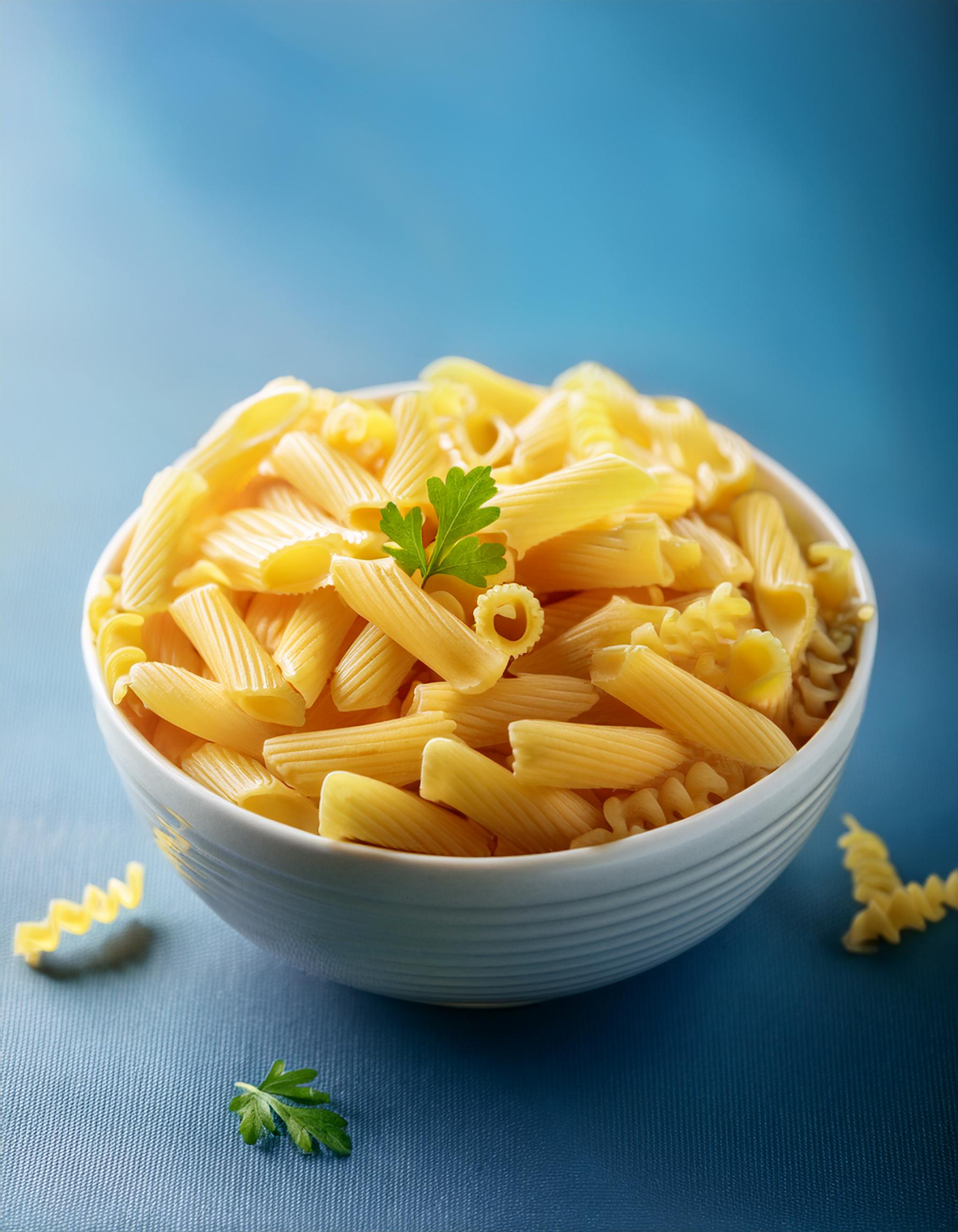 Firefly pasta in bowl with blue background; selective focus 43126